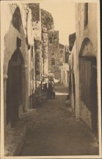 Monemvasia narrow pared street with belltower in the background