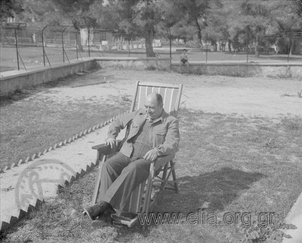 Man in a yard, sitting in a deck chair