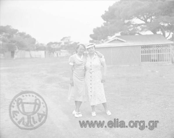 Mrs Nikolaϊdou and a woman pose in the countryside.