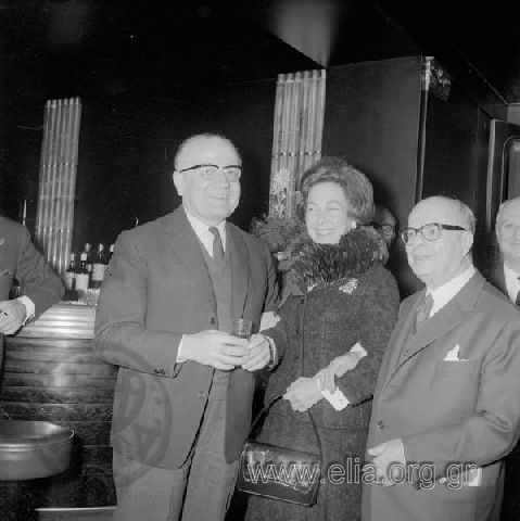 After victory in the elections of February 16th. Georgios Mavros, Minister  of  Coordination and Georgios Bakopoulos, Minister  of Legal Affairs flanKing an unknown lady, possibly wife of G. Mavros. .