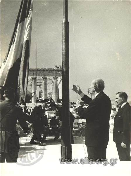 October 18. Celebrations for the liberation of Athens. Prime Minister Georgios Papandreou raises the Greek flag on the Acropolis.