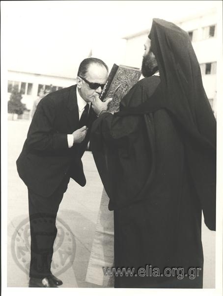 Georgios Papadopoulos kissing the Bible held up to him by a prelate