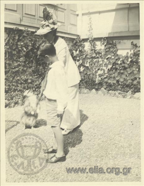 Nikolas Kalas (1907-1988) as a child with a woman and a dog in a garden at Champ Palace.