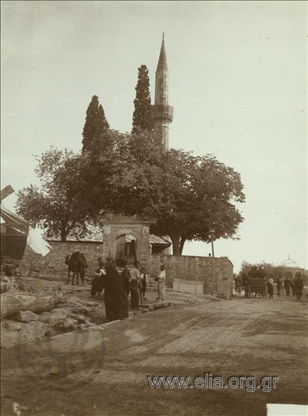 Children and passersby on a cart outside a mosque.