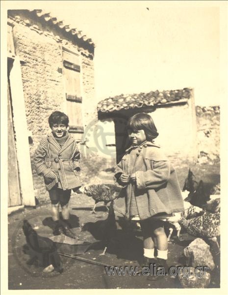 Alexandros and Alma Deligeorgis playing with animals in the yard