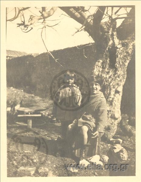 Alexandros and Alma Deligeorgis playing with animals in the yard