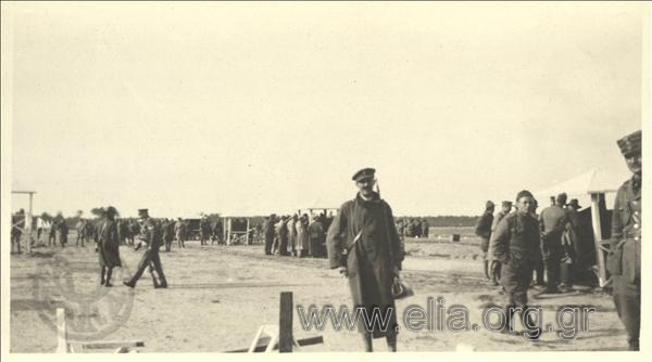 7th Olympic Games, Antwerp 1920. A Greek  sergeant (member of the Greek  firing mission?) in the playing field. At right, a Greek  officer stands out. In the backround foreign soldiers, probably Canadian.