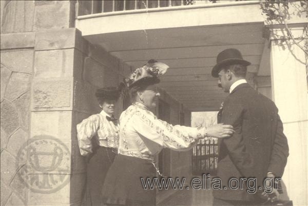 Ο Αλέξανδρος Κ. Βούρος και μία γυναίκα συνομιλούν στην είσοδο κατοικίας.