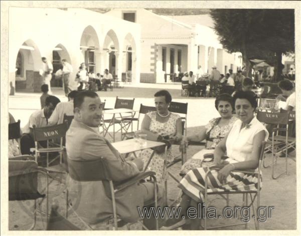 Company sitting in a coffehouse at the illage's square