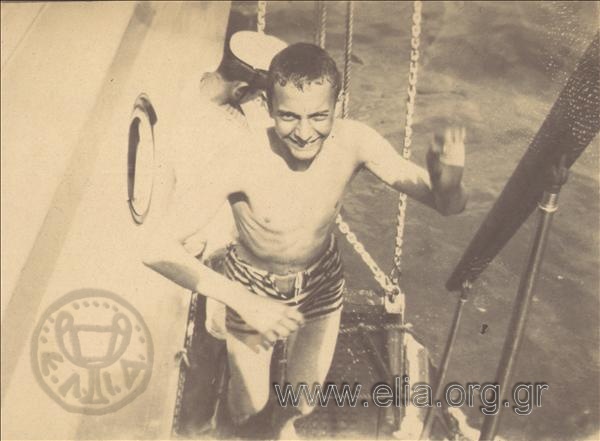 Man getting on board a ship after having been in the sea for a swim