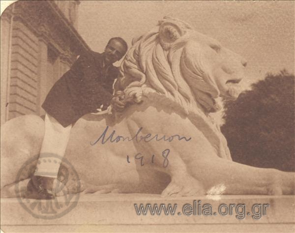 Ο Δημήτριος Γεωργόπουλος καθιστός σε άγαλμα λέοντα, στο Monbenon.