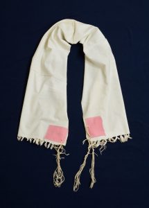 Prayer shawl, handwoven white cotton with pink square corner reinforcements.