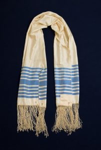 Prayer shawl, cream silk with blue stripes along the edge, white square corner reinforcements, belonged to Elias Koffinas, Ioannina.